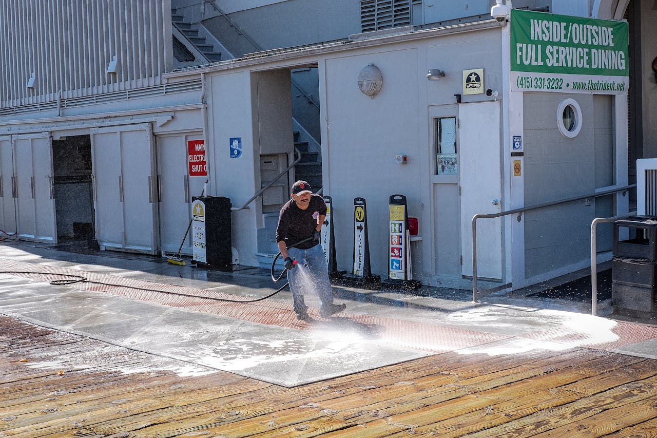 hero-img A worker uses a pressure washer to clean a sidewalk outside a dining facility.
